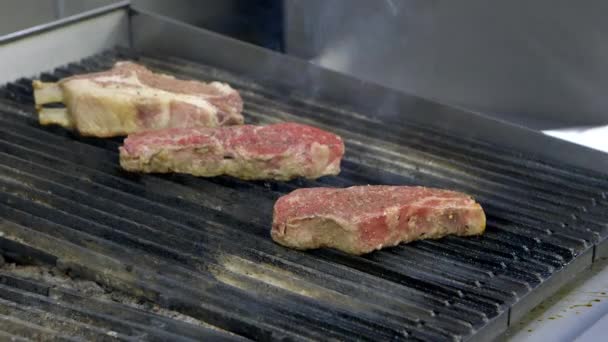 Strip steak a vepřová kotleta na grilu v kuchyni restaurace,