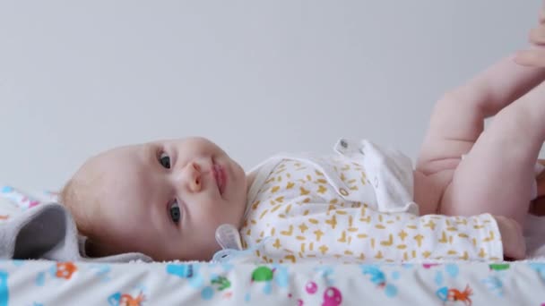 Bebê Recém Nascido Cospe Uma Chupeta Olha Para Câmera Enquanto — Vídeo de Stock