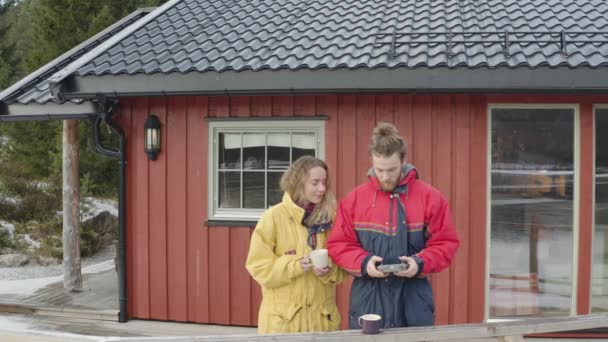 Люди Стоящие Перед Деревянным Домом Держащие Кофейные Чашки Играющие Контроллером — стоковое видео