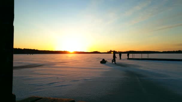 雪に覆われた湖での黄金の夕日 そりの冬の活動 ロングショット — ストック動画