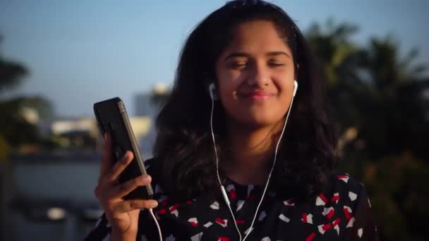 Una Chica Escuchando Música Con Sus Auriculares Puestos — Vídeo de stock