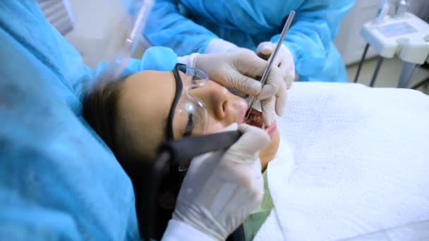 牙科医生在一位年轻妇女的嘴里进行治疗 — 图库视频影像