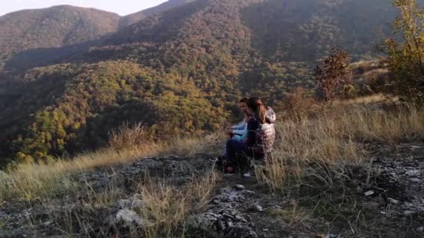 母と兄弟の軌道ショット一緒に座って壮大な山の景色を鑑賞 — ストック動画