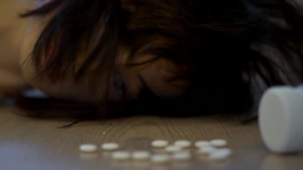 薬を飲んで床に寝そべっている女 ズームアウト — ストック動画