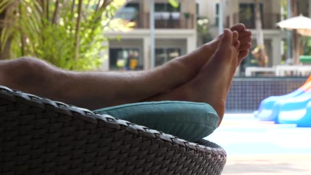 Zblízka nohy na lehátku, dovolená v hotelu, relaxační koncept, statický záběr