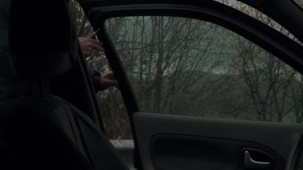 遠くから山の尾根の絶景が広がる道路脇で立ち寄る男 クローズアップ — ストック動画