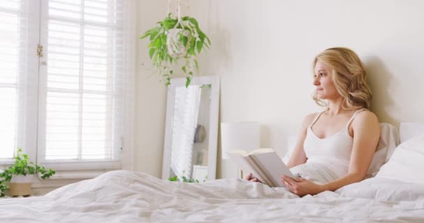 Середній Знімок Привабливої Молодої Блондинки Читає Книгу Ліжку Спальні Вранці — стокове відео