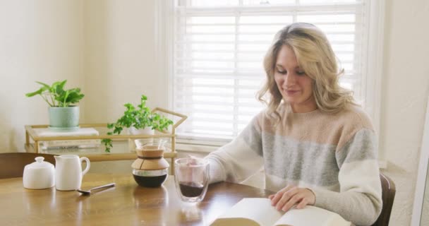 Молодая Привлекательная Женщина Читает Дома Книгу Любит Пить Кофе Кухне — стоковое видео