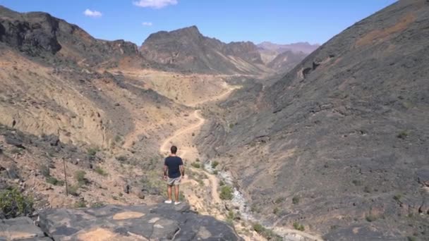 Jovem Veranista Fica Borda Das Montanhas Wadi Bani Awf Levanta — Vídeo de Stock