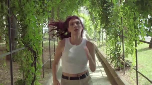 Hipster Dívka Bílou Tílko Běží Pod Břečťanem Arbor Zpomalený Pohyb — Stock video