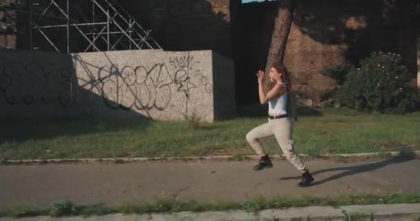 mladá zrzavá žena v bílém tílku běží na chodníku