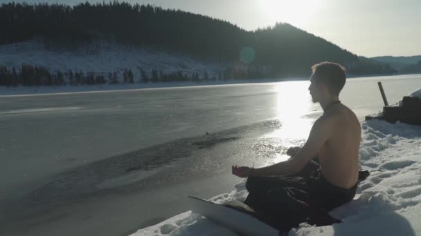 Человек Медитирует Коврике Сидя Снегу Замёрзшего Горного Озера Солнцем Горизонте — стоковое видео