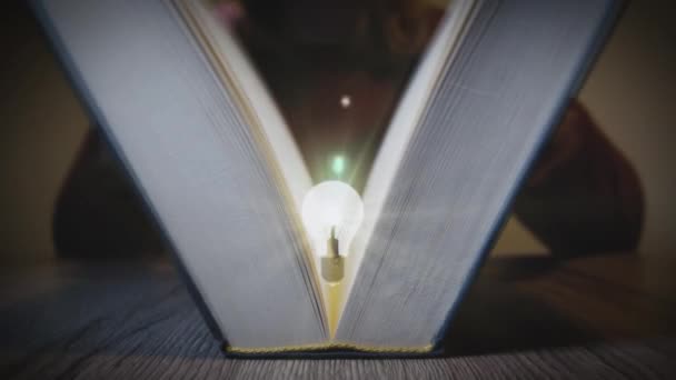 Kniha se otevře a objeví se zářící žárovka. Symbol pro nápad. Digitální generovaná animace.