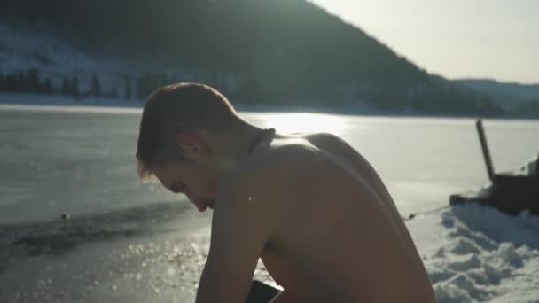 Человек Рубашки Сидит Снегу Замёрзшего Озера Солнечный Свет Светит Ледяной — стоковое видео