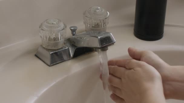 Bílé ženské ruce pumpují dávkovač mýdla a pomalu myjí ruce. Covid-19 prevence.