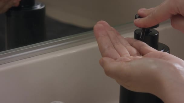 Bílé ženské ruce pumpující mýdlo dávkovač a mytí rukou ve zpomaleném filmu, zblízka.