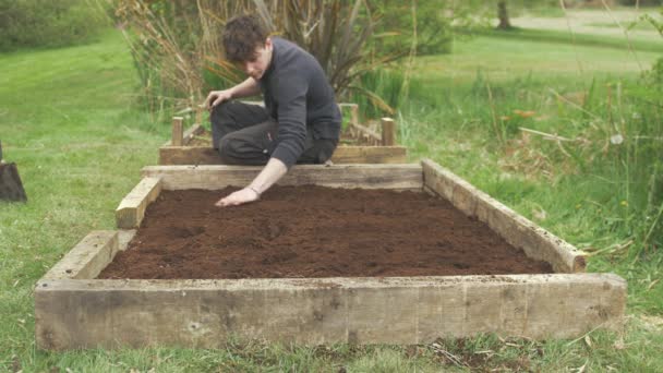 Junger Gärtner Deckt Pflanzkartoffeln Hochbeet — Stockvideo