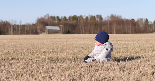 Peuter Jongen Zit Alleen Het Platteland Lente — Stockvideo