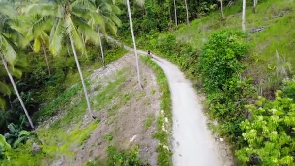 Aerial Pull Back Drone Shot Away Man Motorbike Jungle Road — Video