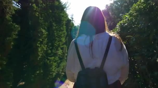 孤独的年轻女子穿着五颜六色的衣服 背着背包 走在自然公园里 — 图库视频影像
