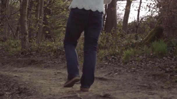 女は森の中を田舎道を歩くワイドパンニングショット — ストック動画