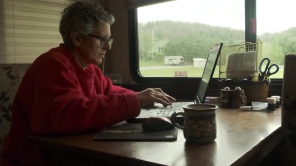 Fehér nő dolgozik laptop és iszik kávét belsejében ötödik kerék lakókocsi, közelről