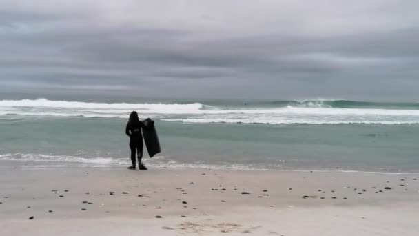 Bir Sörfçü Sörf Tahtasıyla Şafakta Dalgalara Doğru Yürür — Stok video