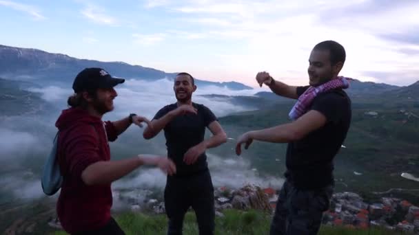 日没時に山の崖の上に円の高い5の3人の若い白人男性 — ストック動画