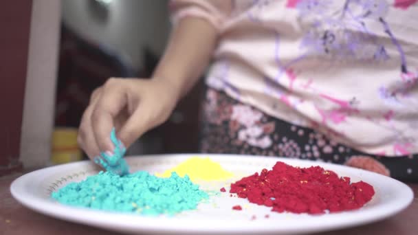 コロナウイルスのロックダウン スローモーションのために家の中のプレートの上に色の粉で遊んで女の子の手 — ストック動画