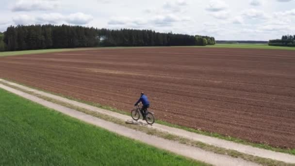 Zdjęcie Mężczyzny Jeżdżącego Rowerze Małej Polnej Drodze Pola Pierwszym Planie — Wideo stockowe