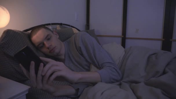 Junger Kaukasier Tippt Nachts Seinem Bett Nachricht Auf Sein Smartphone — Stockvideo