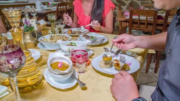近距离拍摄到一些人在外面吃饭 在餐馆里 他们的注意力集中在男人用勺子加酱汁的双手上 — 图库视频影像