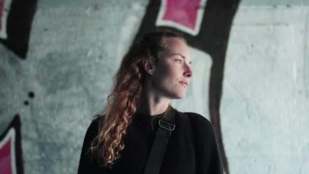 Естественная Кудрявая Девушка Выглядит Скептически Перед Стеной Граффити Копенгагене — стоковое видео