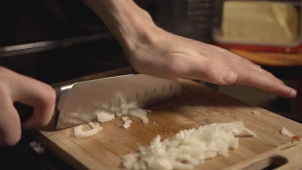 Chefs Hand Mincing A White Onions On A Wooden Cutting Board. - close up shot