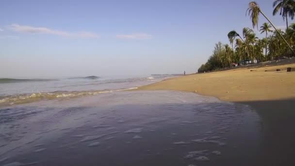 美しい熱帯波の低角度と男はビーチでジョギング 朝の日の出に — ストック動画