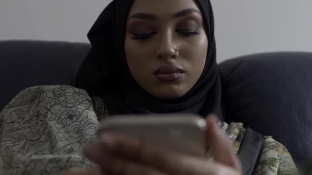 Muslim Woman Browsing Her Smartphone Indoors Sitting Low Angle Locked — Stock Video