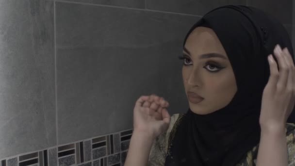 若いイスラム教徒の女性が鏡を見てヒジャブを固定します ロックオフ — ストック動画