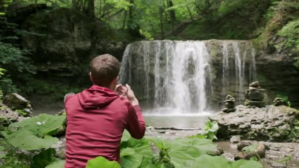 Фотограф Розробляє Свій Поляризаційний Фільтр Чудовим Водоспадом Задньому Плані Фотографія — стокове відео