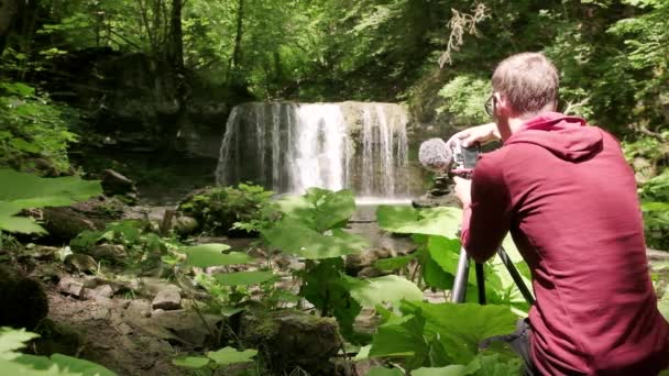 Фотограф Встановлює Камеру Триногу Щоб Зробити Знімок Водоспаду Влітку Фотографія — стокове відео