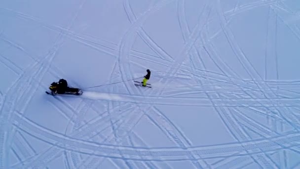 Nádherný Pohled Sněžného Skútru Táhnoucího Lyžaře Žlutých Kalhotách Přes Zasněženou — Stock video