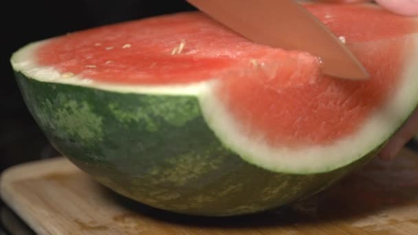 Hand Hält Ein Messer Und Schneidet Die Halb Geschnittene Wassermelone — Stockvideo