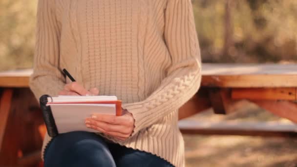 Närbild Kvinna Som Sitter Bänk Och Skriver Papper Bredvid Ett — Stockvideo