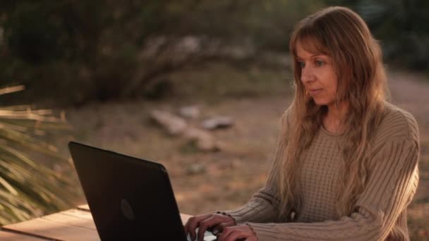 金发女人在花园里打笔记本电脑键盘 在家工作 — 图库视频影像