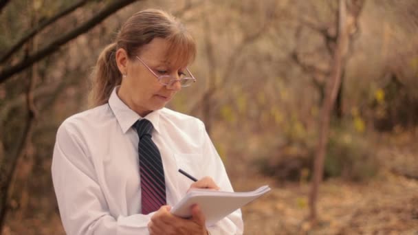 Mulher Escrevendo Artigo Sobre Livro Recortes Cercado Por Árvores Natureza — Vídeo de Stock