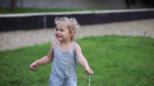 Little Girl Plays Meadow Green Grass Dog Toy Tethered Rope — Stock Video