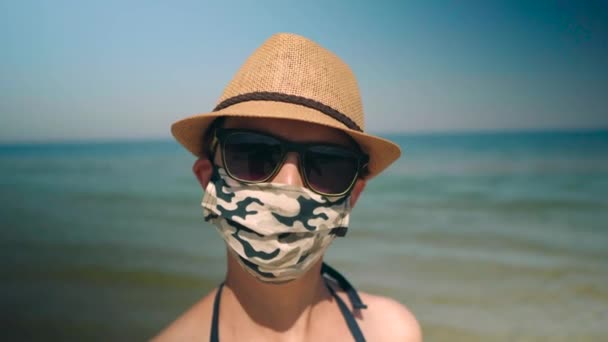 Mujer Lleva Mascarilla Corona Con Gafas Sol Sombrero Frente Playa — Vídeos de Stock