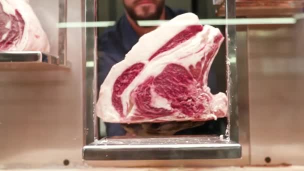 おいしいステーキ 大きな生肉の塊を閉じ 肉屋はショーケースに入れ 調理または販売する準備ができています — ストック動画