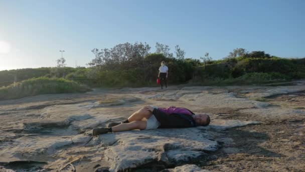 救护助理 急救包走向躺在隐蔽悬崖上的伤员 澳大利亚新南威尔士州 宽射门 — 图库视频影像