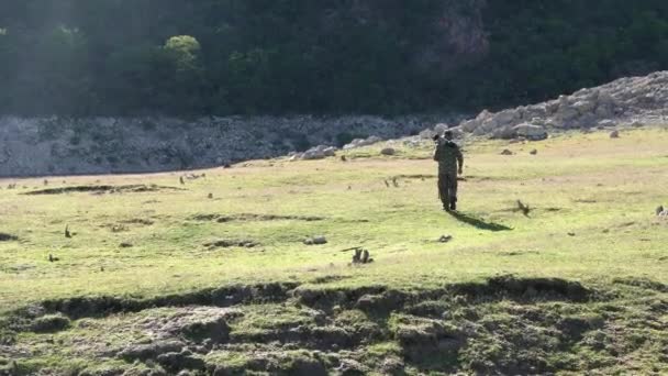 Tierfotograf Läuft Mit Teleobjektiv Und Tarnkleidung Auf Einer Wiese — Stockvideo