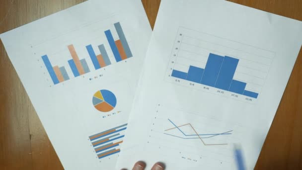 Ovanifrån Papper Med Olika Färgglada Linje Grafer Stapeldiagram Och Cirkeldiagram — Stockvideo